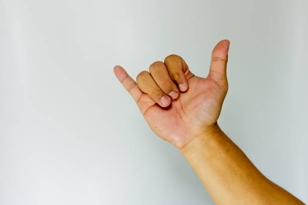istock hand makes a welcome gesture of surfers on a grey background. Banner. Aloha gesture 1593497176