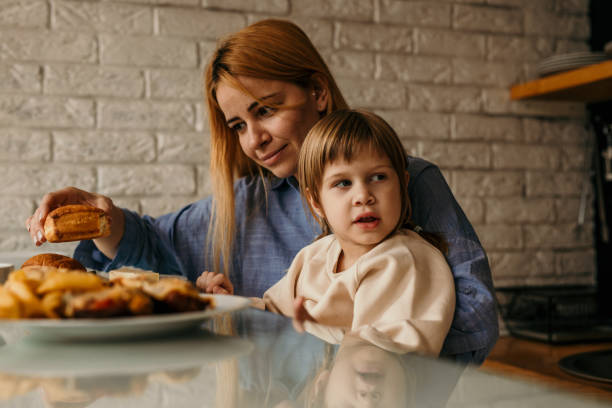 istock A mother and her daughter playfully stacking their breakfast plates while sharing laughter and stories around the table. 1593589989