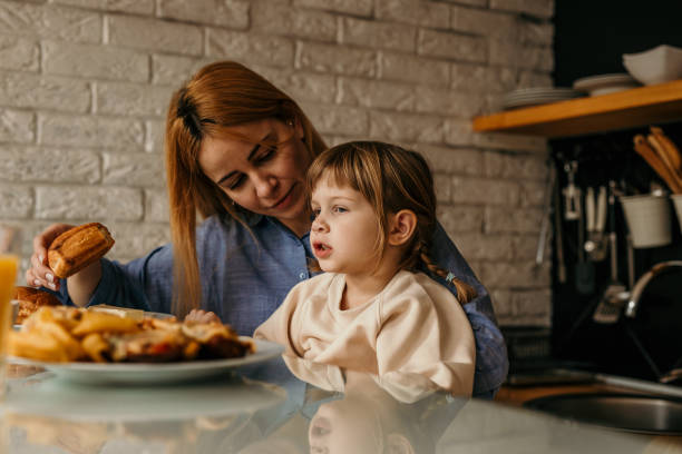 istock A mother and her daughter playfully stacking their breakfast plates while sharing laughter and stories around the table. 1593591579