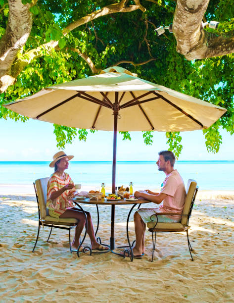 istock Man and Woman having breakfast on a tropical beach in Mauritius 1593628190
