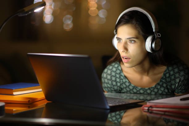 istock Amazed student checking laptop content in the night 1593628411
