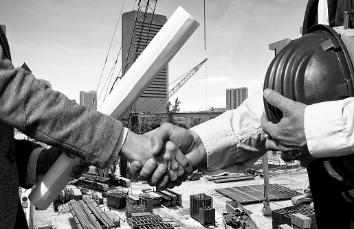 Two engineers handshaking in construction site, Miami, Florida.