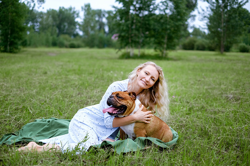 young woman playing with English Bulldog at park