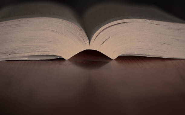 istock an old open book above a wooden table 1593657813