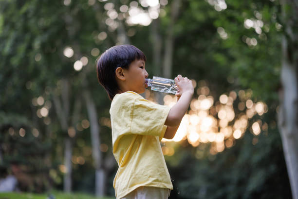 istock An Asian boy drinking water outdoors 1593703809