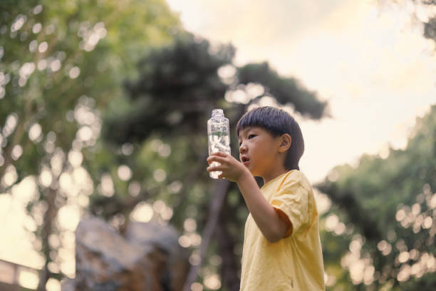 istock Asian little boy drinking water outdoors 1593703827