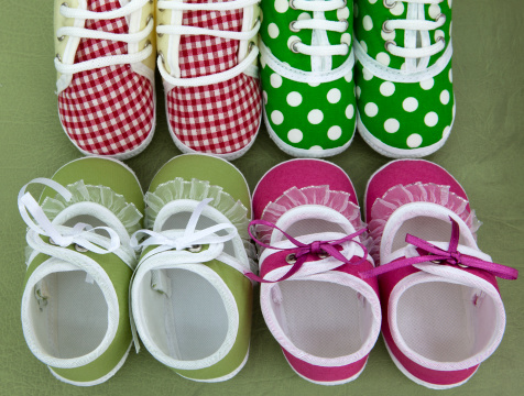 Four diffirent color of baby shoes, rad and green color.