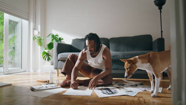 istock Inspired painter creating artwork in workshop. Domestic dog looking at pictures 1593721557