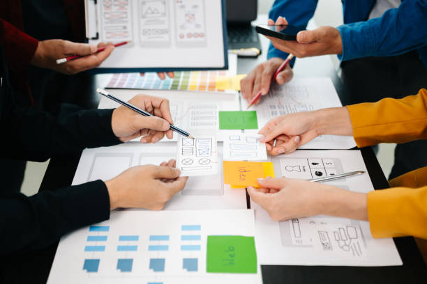 istock Close up view of UI developer team brainstorming on their project with laptop, smartphone and digital tablet. Creative digital development agency. 1593742312
