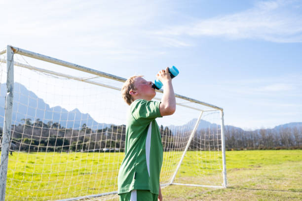 istock Young boy drinking water after his soccer match 1593757532