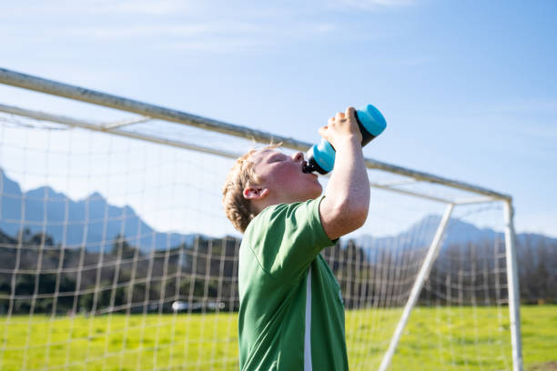 istock Young boy drinking water after his soccer match 1593757898