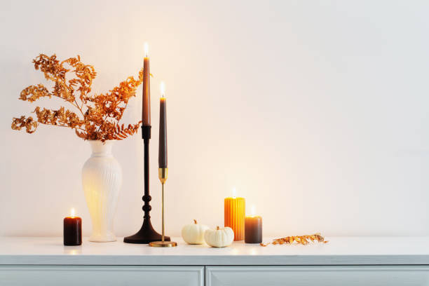 istock beautiful autumn home decor with burning candles in white interior 1593758444