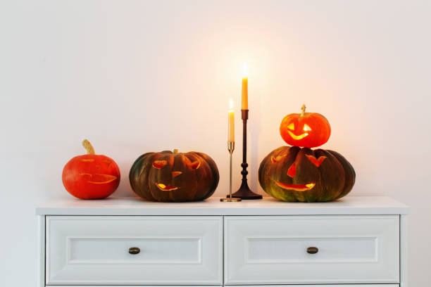 istock halloween pumpkins with burning candles in white interior 1593758446