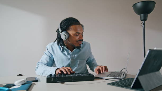 istock Headphones man using controller apartment closeup. Music producer working home 1593776457