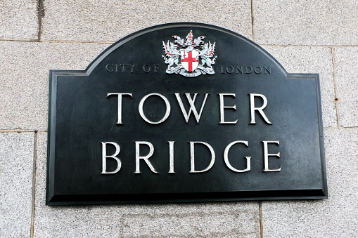 Tower Bridge Sign Plaque with the City of London logo and coat of arms, on the wall of the iconic bridge, signage of famous London attraction