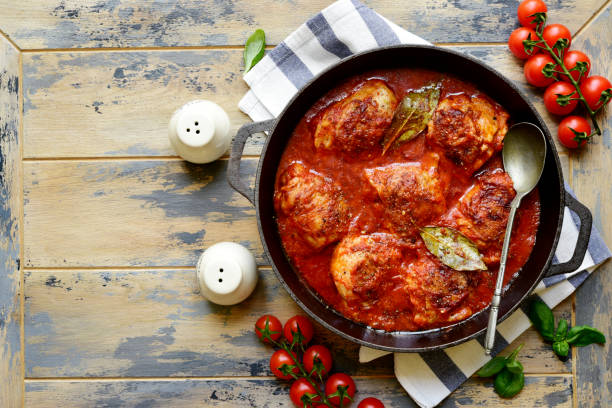 Chicken thigh stew in tomato sauce with vegetables. Top view with copy space. stock photo