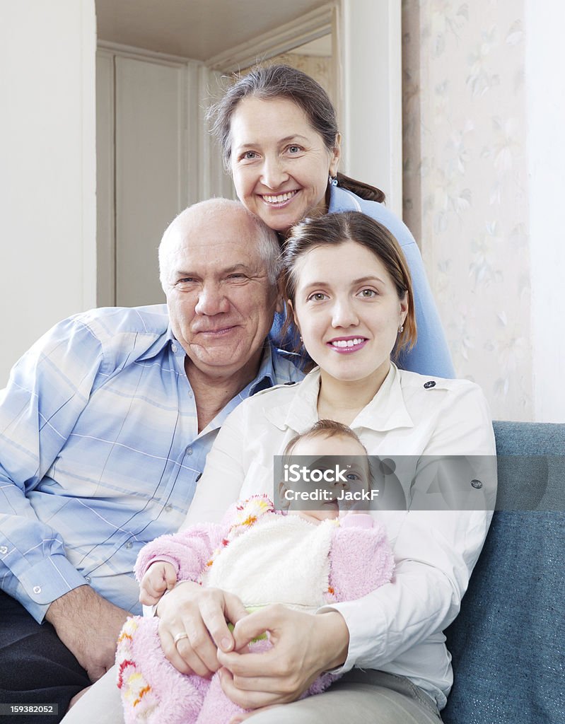 happy grandparents with daughter and granddaughter Portrait of happy grandparents with daughter and granddaughter in home interior 40-49 Years Stock Photo