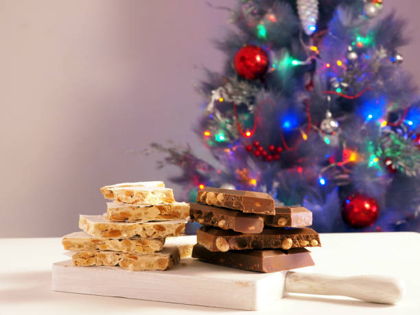 istock Traditional Spanish almond dessert - Torrone candy on a Christmas tree background 1593830562