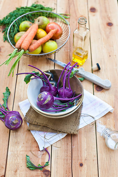 свежий фиолетовый кольраби в миску с корнеплодов - kohlrabi carrot apple bottle стоковые фото и изображения