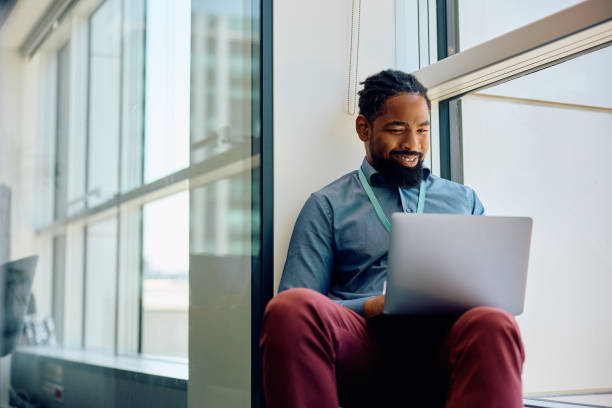 istock Happy black entrepreneur using laptop by the window in the office. 1593913811