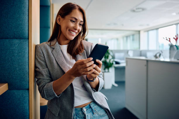 istock Happy female entrepreneur using smart phone in the office. 1593916217