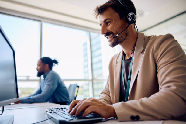 istock Happy male entrepreneur with headset working on a computer in the office. 1593916230