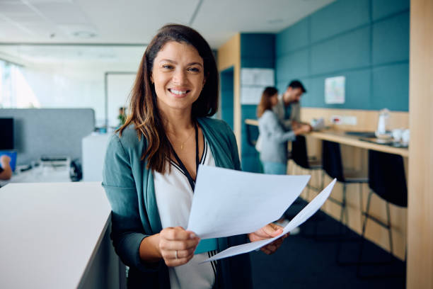 istock Happy businesswoman analyzing documents in the office and looking at camera. 1593916929