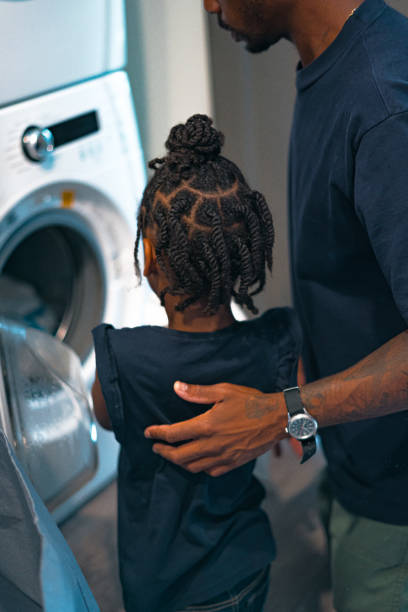 Father and daughter doing laundry together.