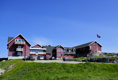 Picturesque panorama of town Husavik, colorful houses and church reflect in the sea water, Northern Iceland. Popular tourist destination in Europe