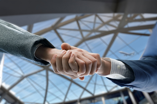 Welcoming handshake of two businessmen at the airport.