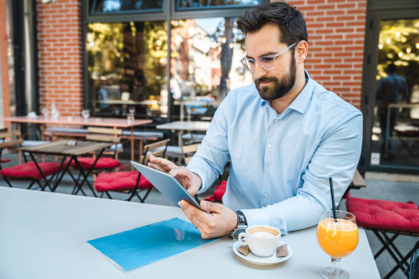 istock Dedicated businessman sitting outdoors and having a coffee break 1594036672
