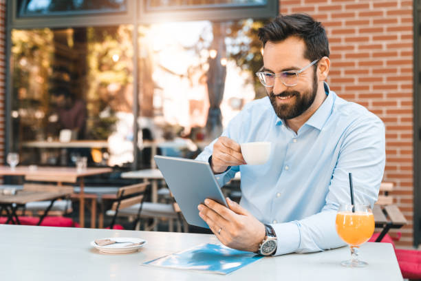 istock Handsome smiling CEO sitting outdoors and drinking coffee 1594037193