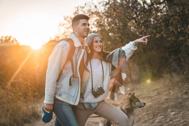 istock Two young people enjoying a walk in nature with a dog 1594048764