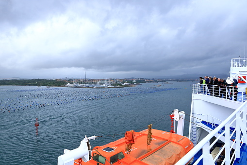 May 20 2023 - Olbia, Sardinia in Italy: : the ferry approaching the the port of Olbia on a cloudy day