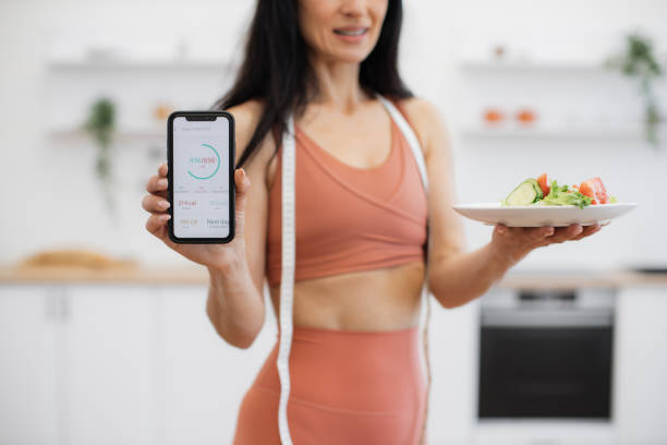 istock Female showing fitness tracker while posing on camera indoor 1594114116