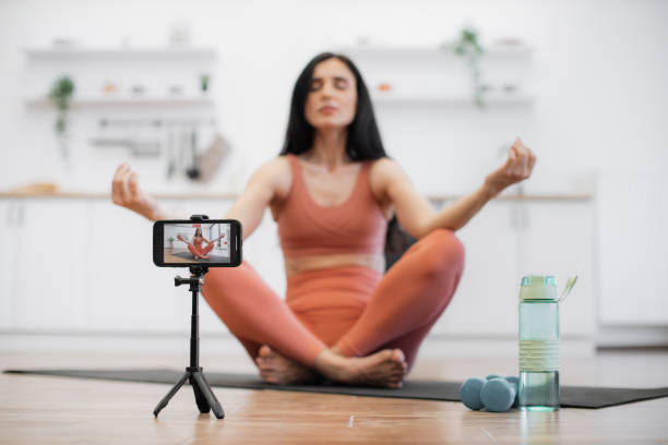 istock Lady recording video while meditating in lotus position 1594114691