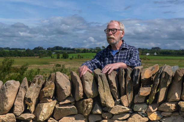istock One senior man standing behind a stone wall 1594118457