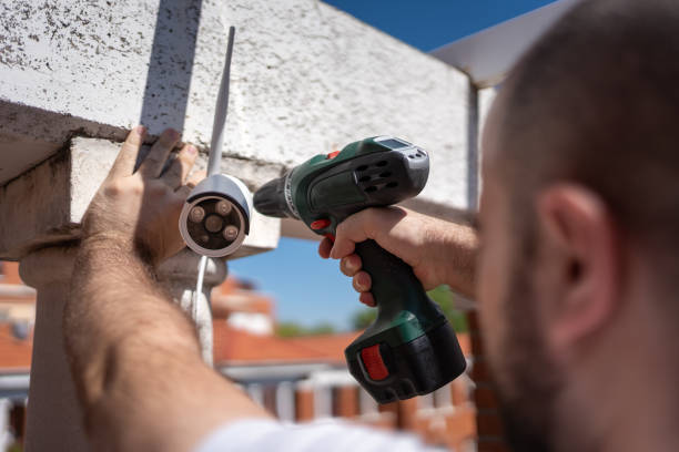 istock Man with a drill installing security cameras for surveillance in a house. 1594137742