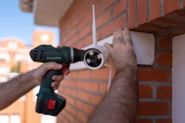 istock Man with a drill installing security cameras for surveillance in a house. 1594138251