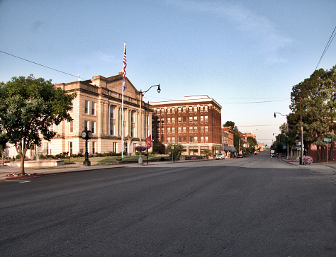 A westward view of Route 66 at sunrise with the historic Creek County courthouse in the foreground.