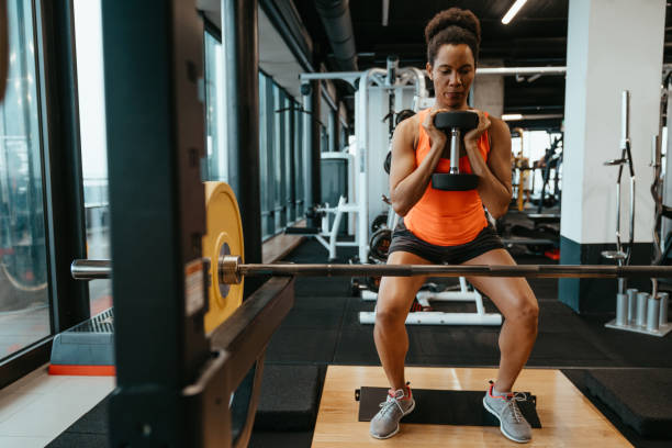 istock Young dedicated fit woman with sweat doing exercises with weights, working out with dumbbell at gym 1594151647