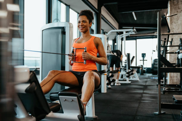 istock Young smiling woman doing cable row exercise 1594151667