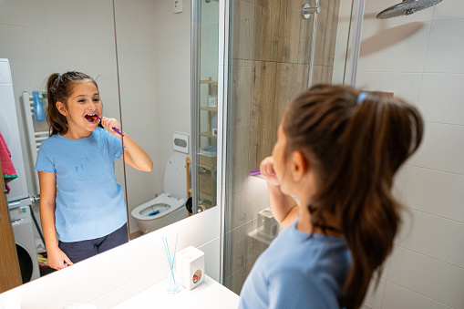 8 Year old girl brushing her teeth