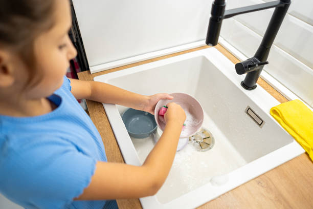 istock 8 year old girl doing dishes 1594153943