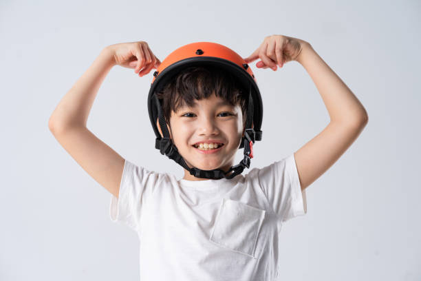 istock portrait of asian boy wearing orange helmet on white background 1594159607
