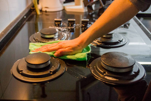 Woman Cleaning The Stove After Dinner stock photo