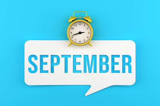Alarm Clock And September Speech Bubble On Blue Background. Deadline Concept. Months Of The Year.