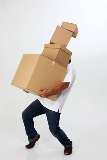 istock man struggling to carry moving boxes. 1594179133