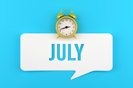 Alarm Clock And July Speech Bubble On Blue Background. Deadline Concept. Months Of The Year.