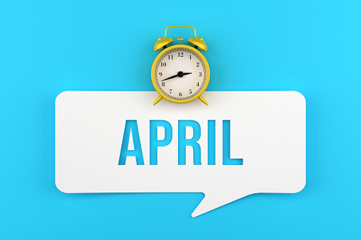 Alarm Clock And April Speech Bubble On Blue Background. Deadline Concept. Months Of The Year.